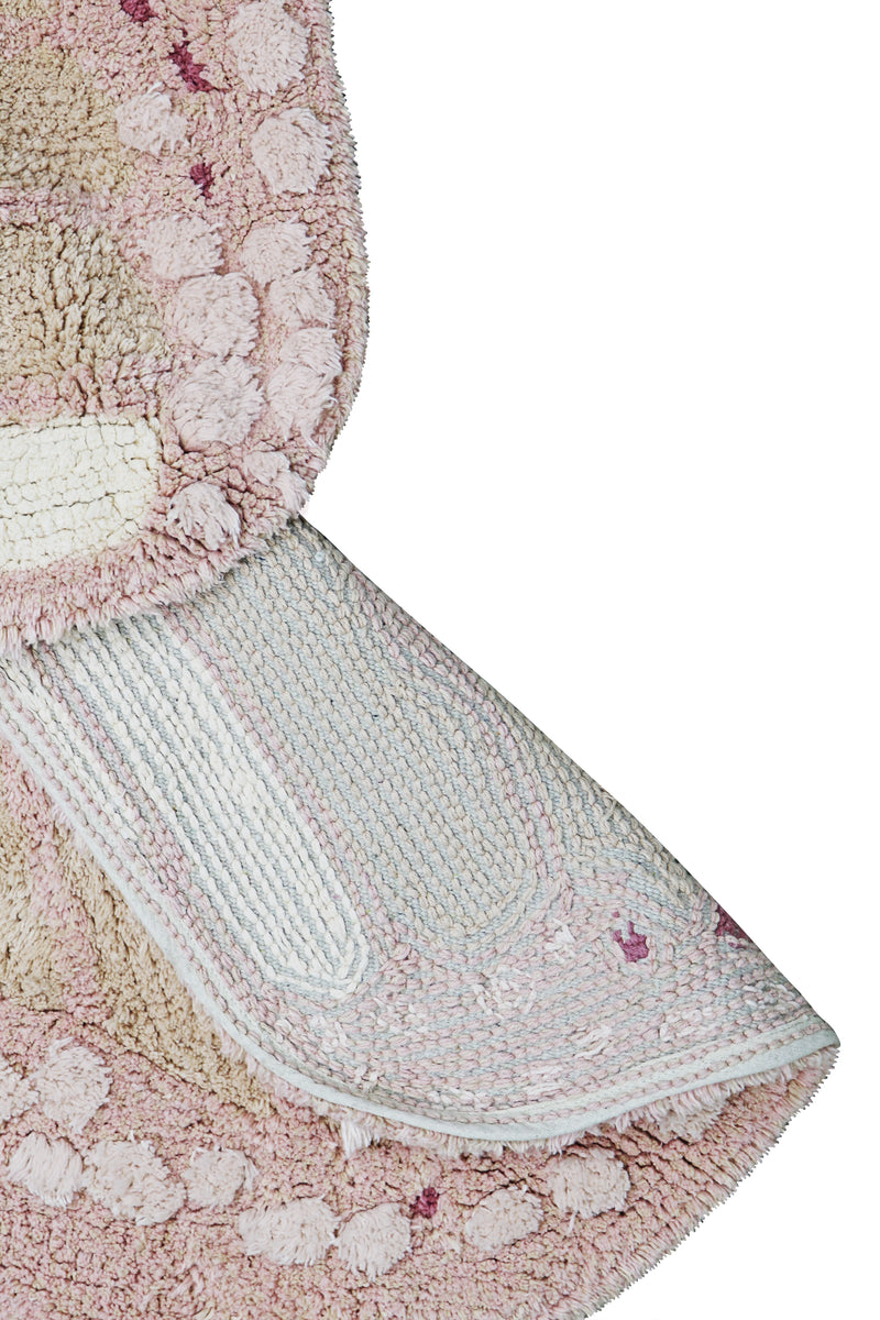 Close-up of a textured pink and white rug with floral patterns on a white background