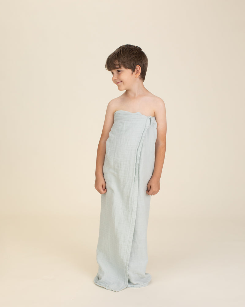 toddler wearing aqua organic cotton gauze swaddle