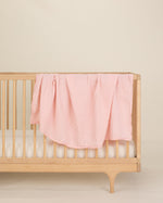 light pink organic cotton gauze swaddle on crib 