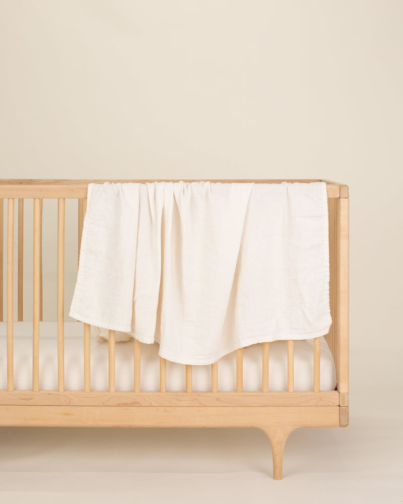 ivory undyed organic cotton gauze swaddle on crib 