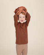 rust organic cotton gauze swaddle on head