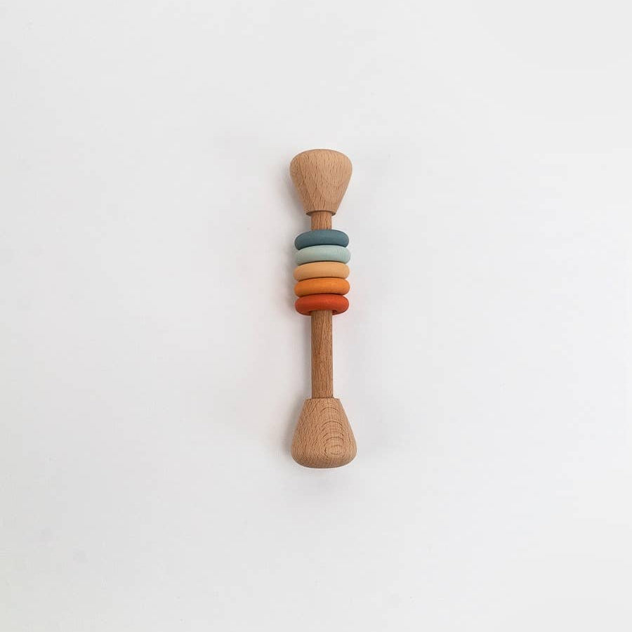 Wooden rattle with colorful rings on a white background