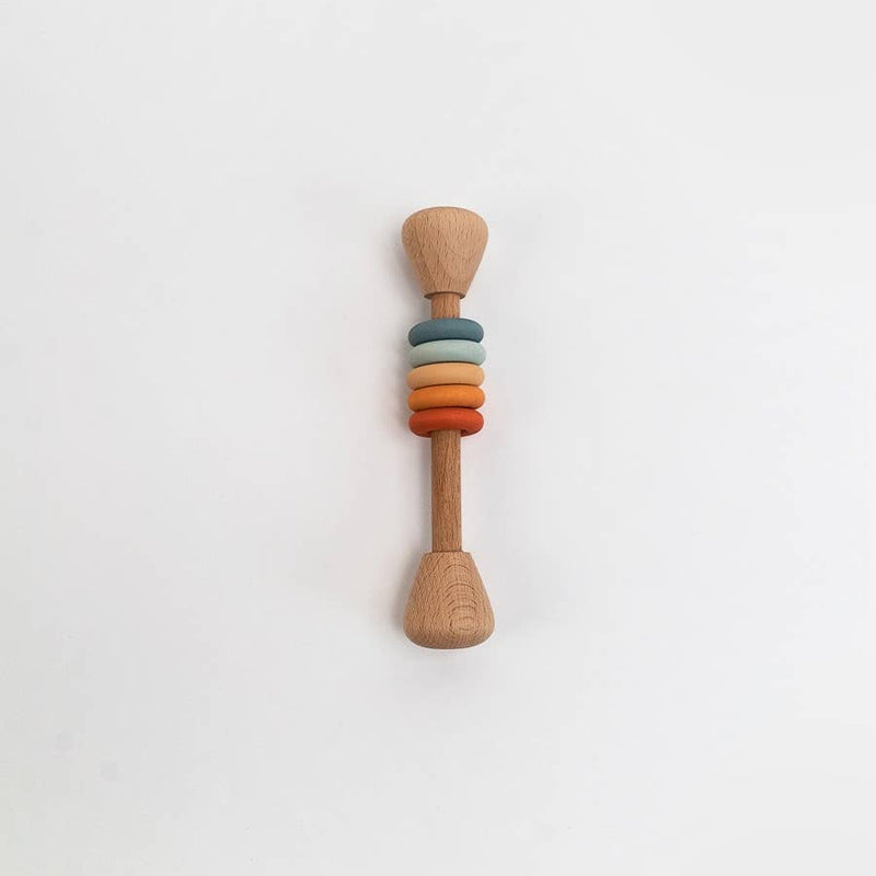 Wooden rattle with colorful rings on a white background