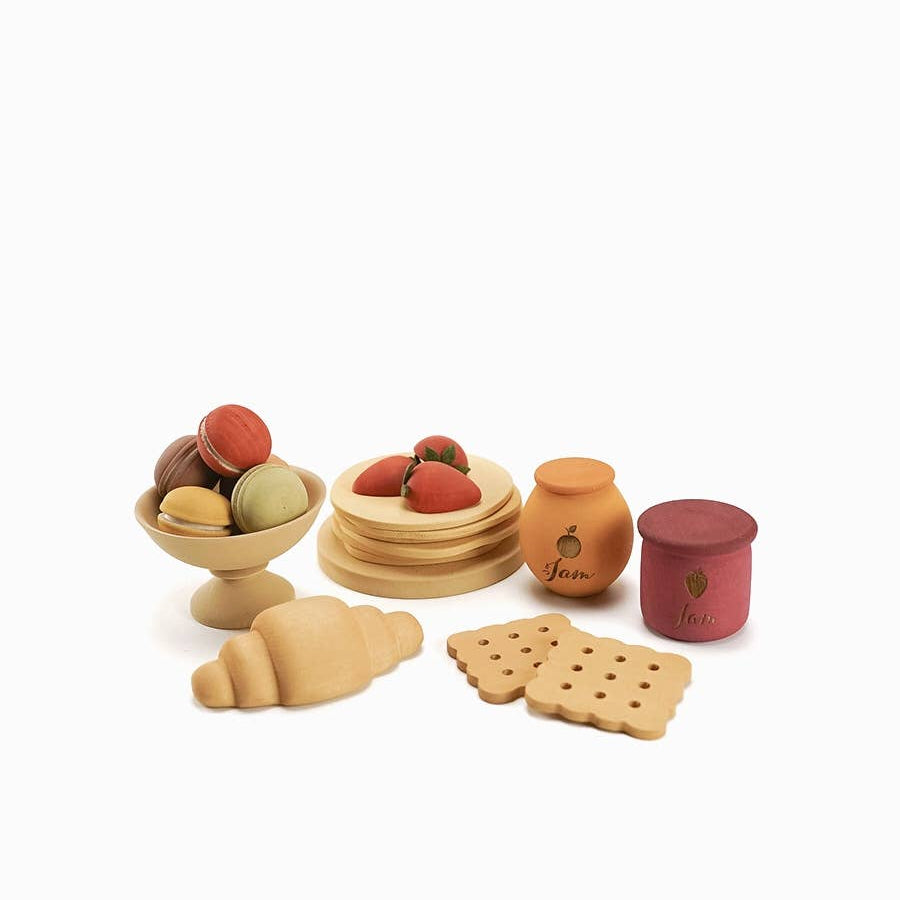 Set of wooden food items including fruits, bread, and pastries on a white background