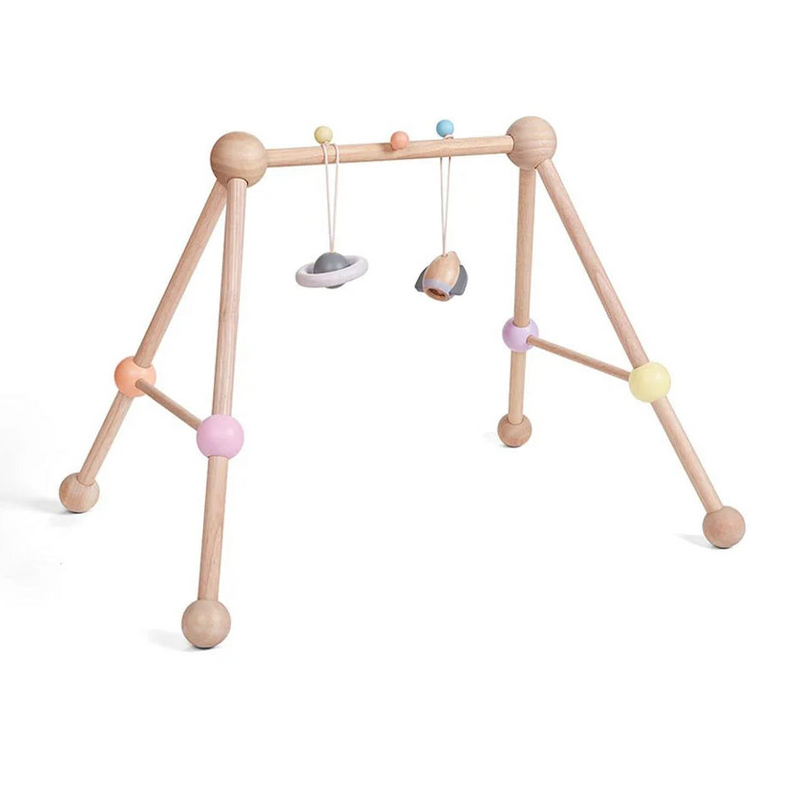 Wooden baby gym with colorful hanging toys on a white background