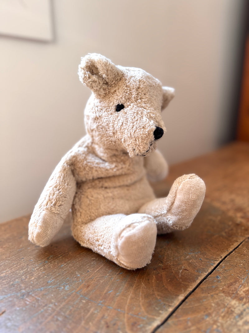 Stuffed animal toy on a wooden surface with a neutral background
