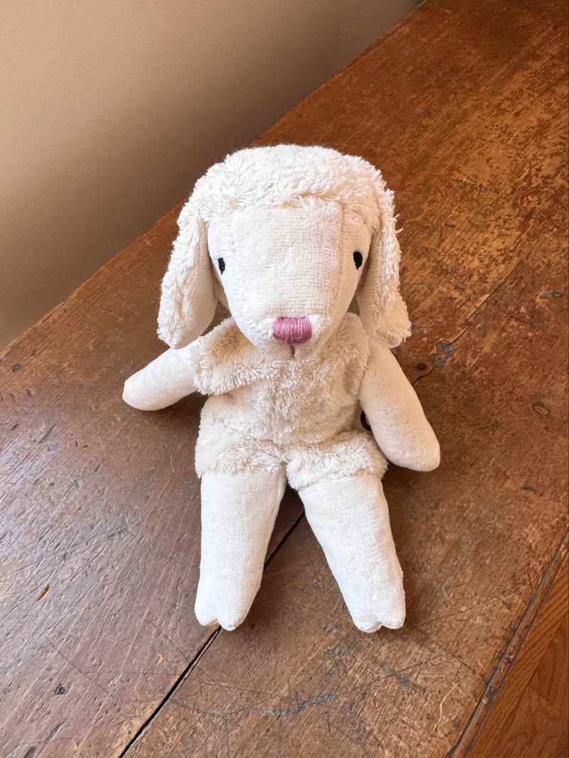 White plush bunny toy on a wooden surface