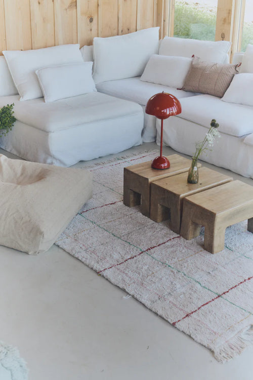 Modern living room with a white sectional sofa, wooden coffee table, and decorative items.