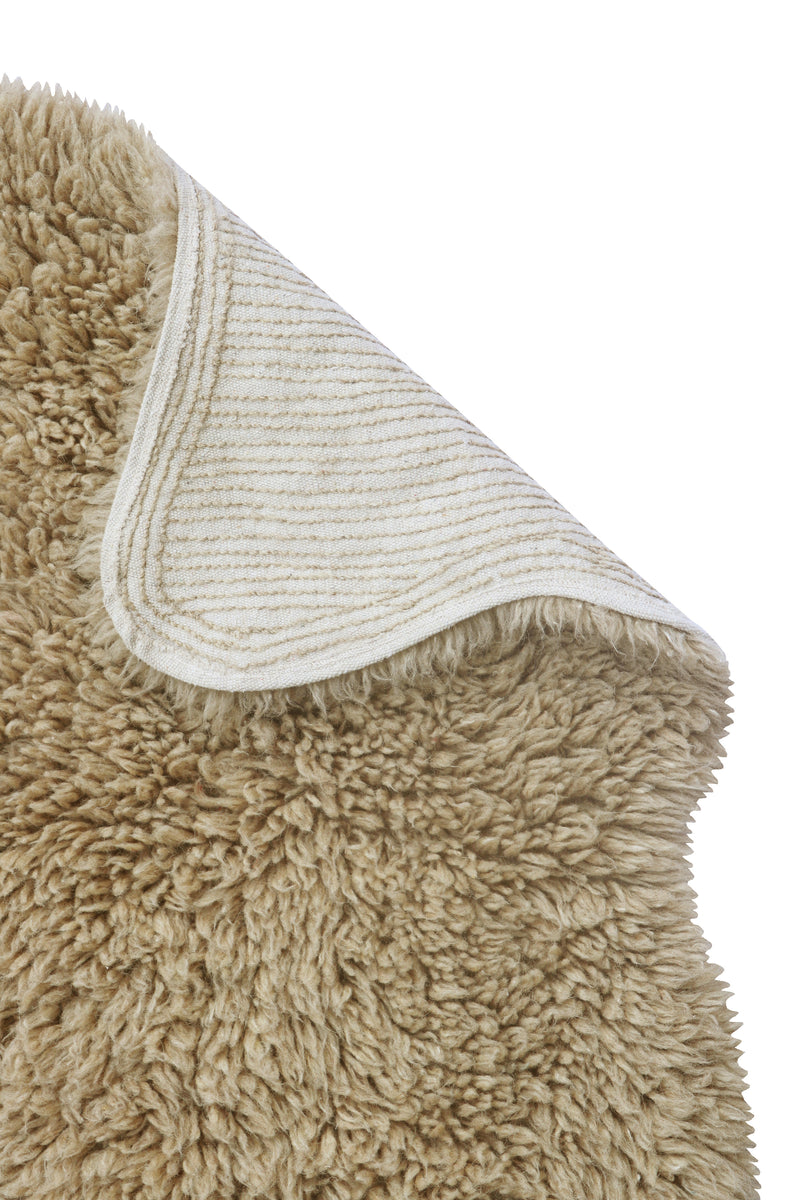 Close-up of a beige textured rug corner on a white background