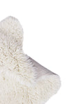 Close-up of a fluffy white sheep rug corner on a white background