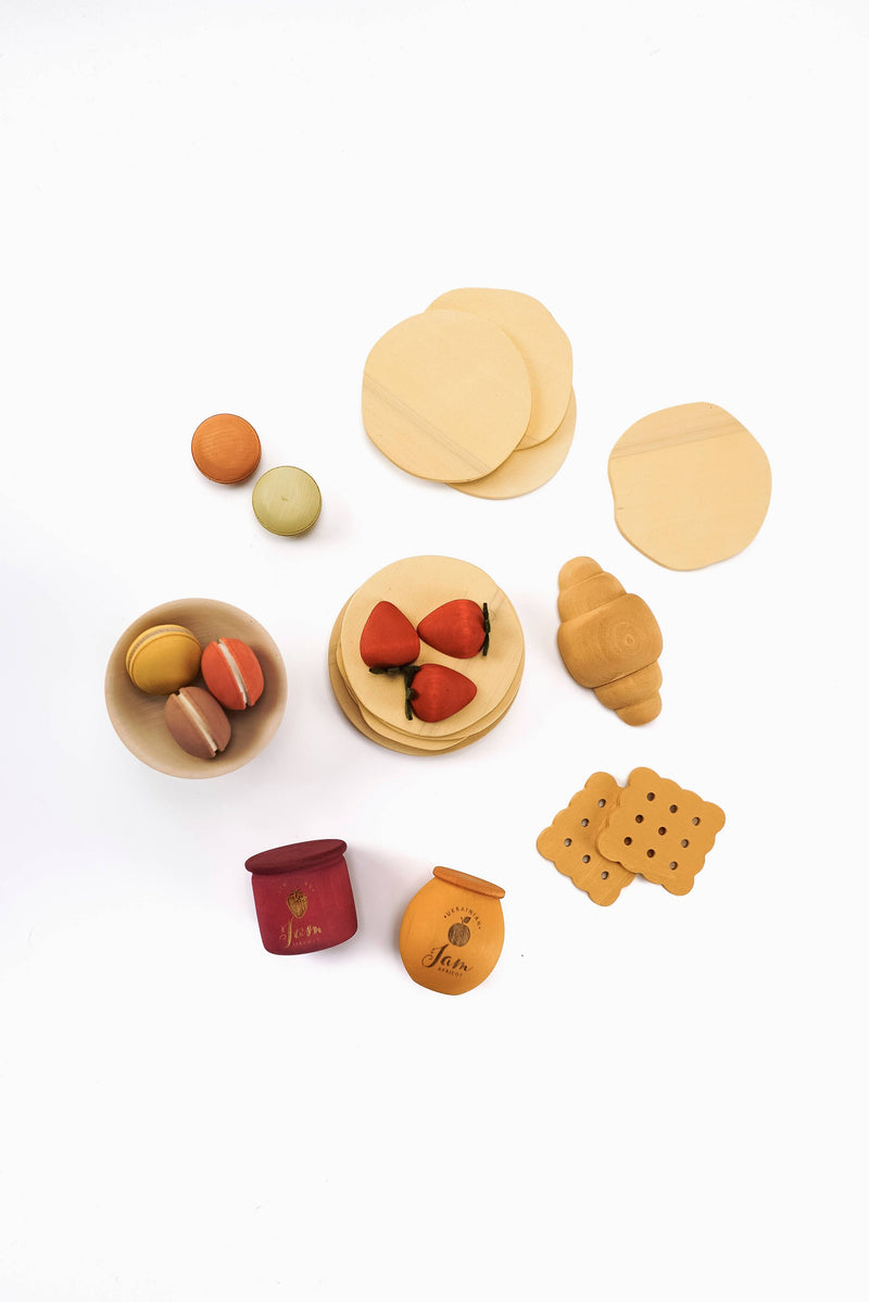 Collection of wooden toy food items on a white background