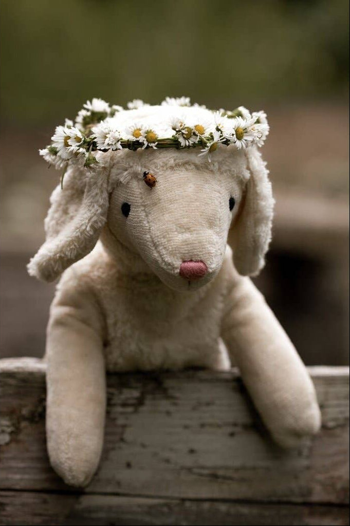 Stuffed animal with a flower crown on a wooden surface