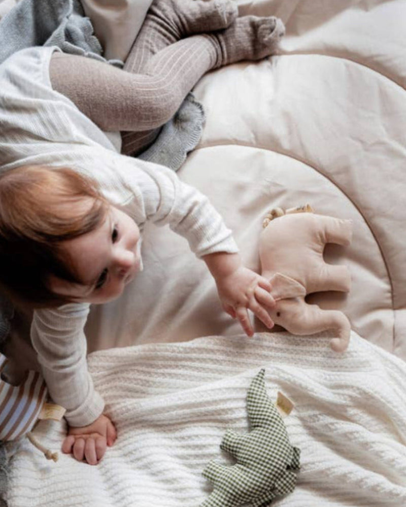 Baby playing with toys on a soft blanket