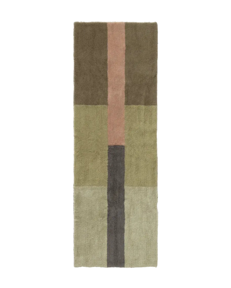 A rectangular area rug with a modern geometric block pattern in muted earthy tones, including olive green, dusty pink, dark gray, and beige, shown flat against a solid white background.