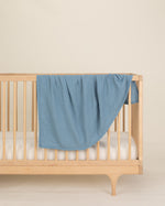 blue organic cotton gauze swaddle on crib