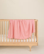 pink organic cotton gauze swaddle on crib 
