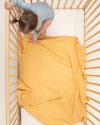 gold organic cotton gauze swaddle in crib 