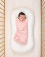 baby wrapped in light pink organic cotton swaddle