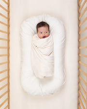 baby wrapped in undyed ivory organic cotton swaddle