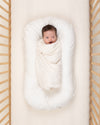 baby wrapped in undyed ivory organic cotton swaddle